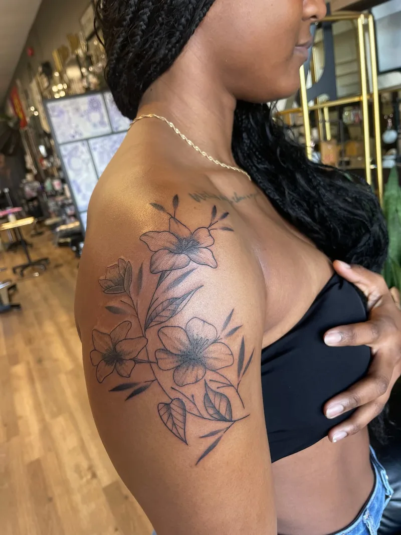Floral shoulder tattoo by Jesse Grim