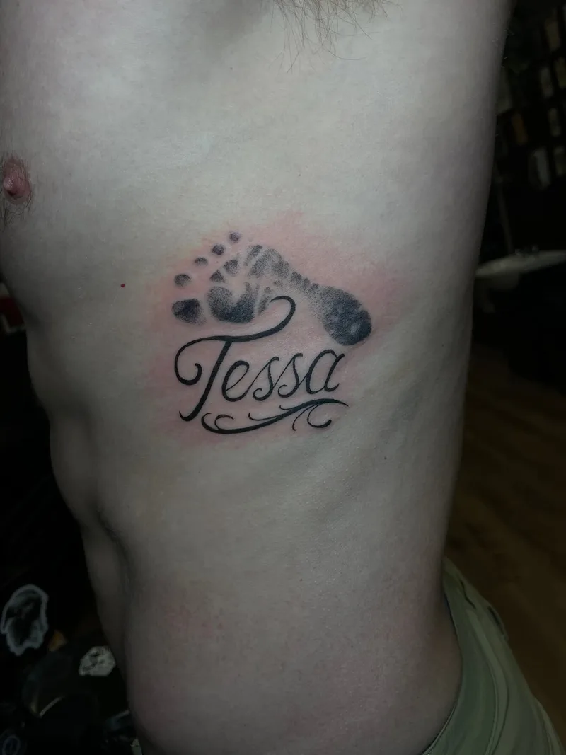 Name tattoo with baby footprint by Jesse